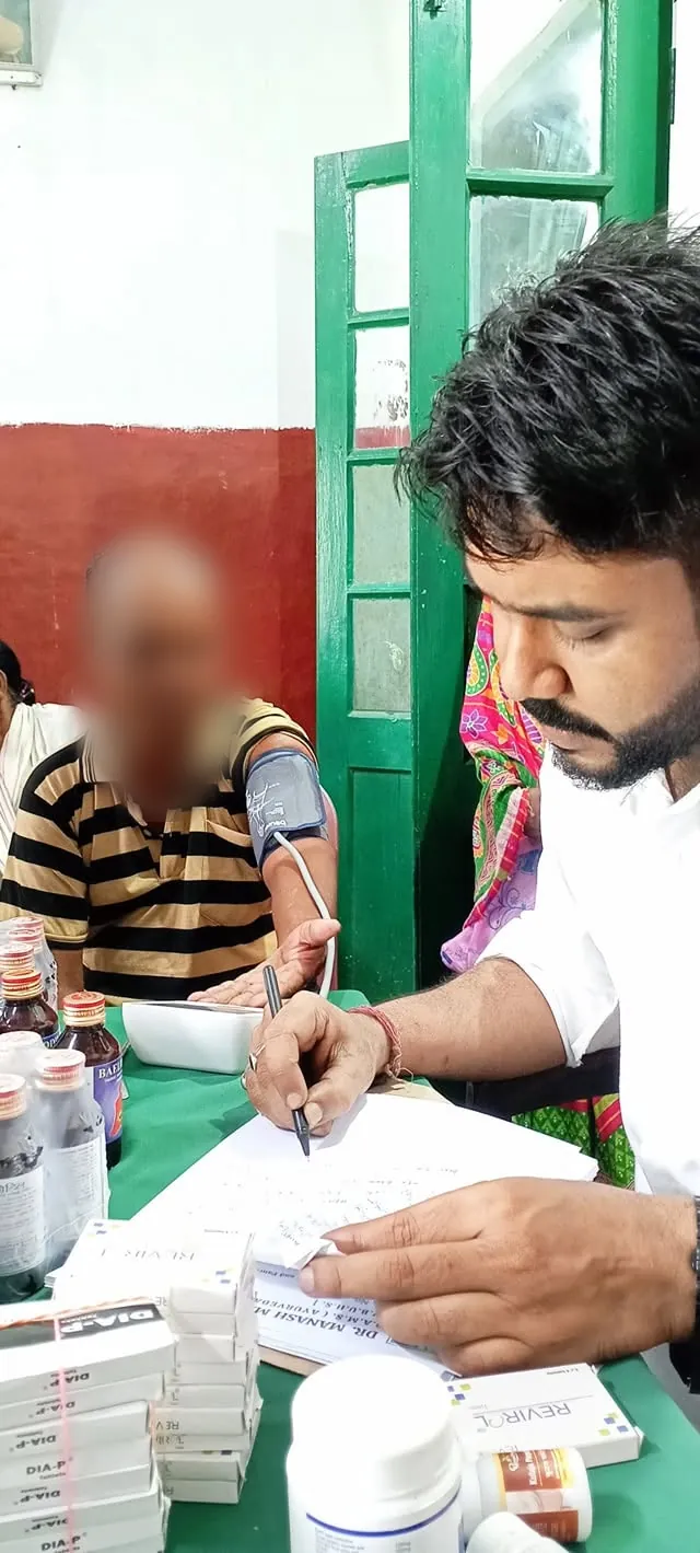 Doctor writing a prescription at the free health camp